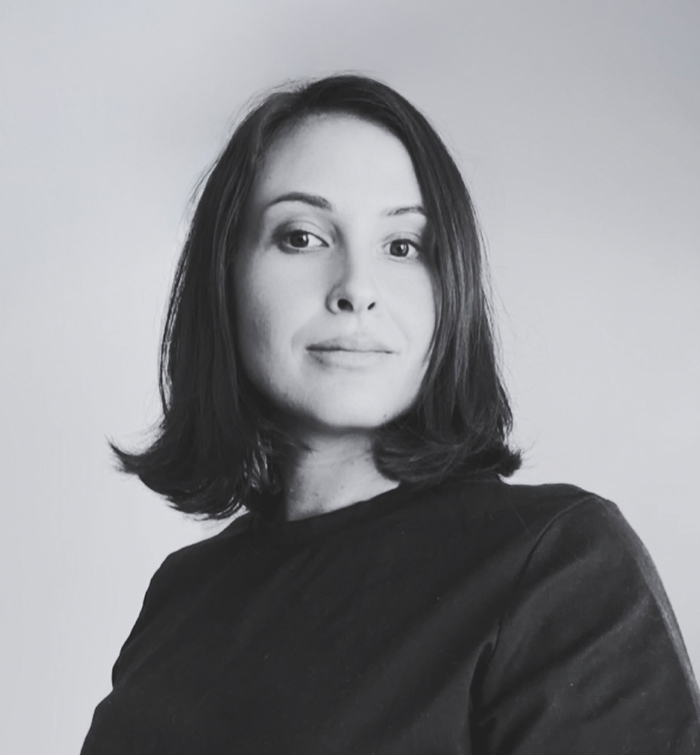 Black-and-white portrait of Coco Holtz against a softly lit grey backdrop.