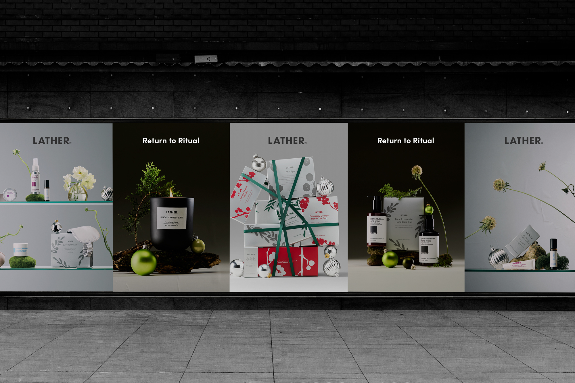 LATHER storefront window display for the 'Return to Ritual' holiday campaign — five vertical panels alternating the wordmark, a lit Hinoki Cypress & Fir candle, a tower of ribbon-bound gift boxes, and a Pear & Lavender Hand Care Duo.